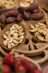 dried dates and walnuts on a wooden dish. vertical photo of oriental sweets