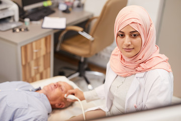 High angle portrait of young Arab woman working as doctor in medical clinic and performing...