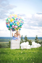 Little cute girls kids beautiful and happy on green grass with balloon airship on blue sky background with clouds