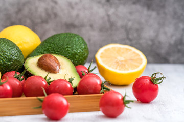 Naklejka na ściany i meble Healthy weight loss fruit meal-avocado, lemon and cherry tomatoes in a tray