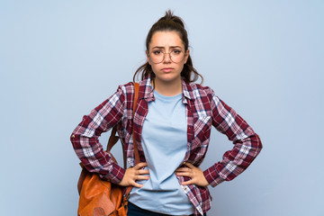 Teenager student girl over isolated blue wall angry