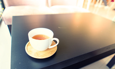 hot tea in white cup on black table in coffee shop