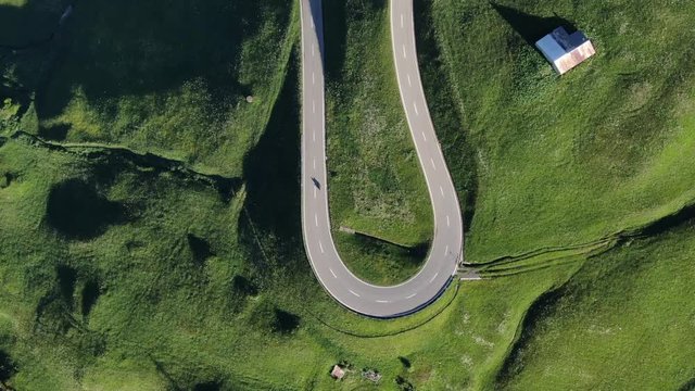 Drone view to the serpantene road surrounded by green fields in Switzerland