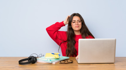 Teenager student girl studying in a table having doubts while scratching head