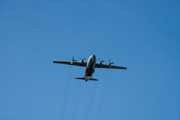 Fototapeta na wymiar gray military plane flies in the blue sky Peaceful flight demonstration. Day of the city. Memory