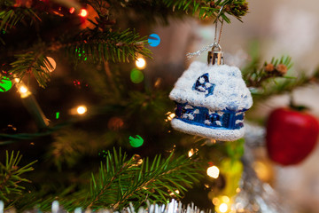 bombka w kształcie domu wisząca na świątecznej choince podczas Świąt Bożego Narodzenia