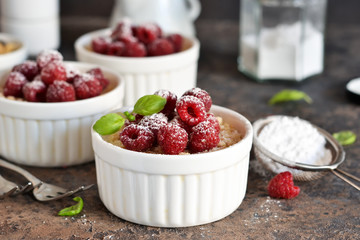 Cheesecake - The classic dessert cheese cream with raspberries. Dessert on the kitchen table. Souffle with cream and berries.