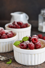 Cheesecake - The classic dessert cheese cream with raspberries. Dessert on the kitchen table. Souffle with cream and berries.