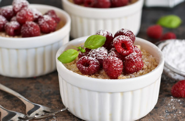 Cheesecake - The classic dessert cheese cream with raspberries. Dessert on the kitchen table. Souffle with cream and berries.