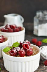 Cheesecake - The classic dessert cheese cream with raspberries. Dessert on the kitchen table. Souffle with cream and berries.