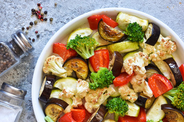 Many different vegetables and spices baked in the oven. View from above.