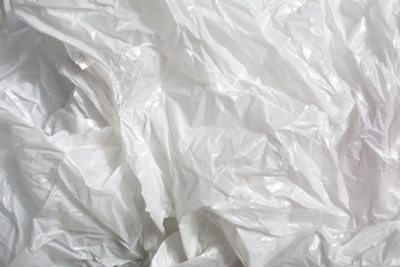 white plastic bag on white background. A White Plastic Bag Texture, macro, background. Reduction of plastic bags for natural treatment. The symbol of the campaign to refrain from using plastic bags.