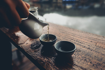 Tea and coffee at a wooden bar with a reservoir view at Ban Rak Thai, Mae Hong Son