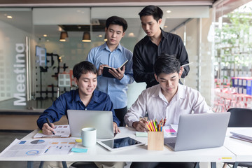 Team collaboration meeting start up. Group of young Asian men who using laptop computer to discuss and talking at office.