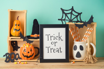 Halloween holiday concept with photo frame, jack o lantern cup, candy corn and decorations on...