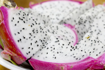 Healthy dragon fruit or pitaya pieces background, close up of beautiful fresh sliced dragon fruit with texture in the market in thailand. Pitaya is the plant in Cactaceae family or Cactus.