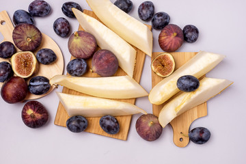 Tasty Fresh Fruits Melon Plums and Figs on Wooden Cuting Board on Blue Background Harvest Autumn Background Horizontal Top View