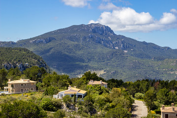 Fototapeta na wymiar Weitblick auf die Landschaft rund um die Siedlung George Sand mit dem Aussichtspunkt Puig de la Moneda im Norden von Mallorca an einem sonnigen Tag