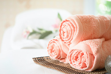 Stack of clean soft towels with flower decoratedin spa salon.