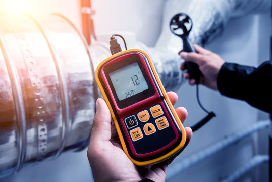 Technician use hand-held anemometer measuring air flowing measurement, wind speed and pressure.