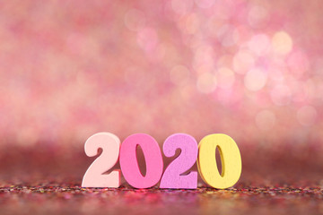 Holiday image of New Year 2020 concept. Wooden number and sparkling background