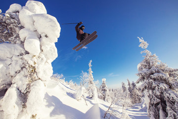 Skier jump in mountains against background forest. Extreme sport concept