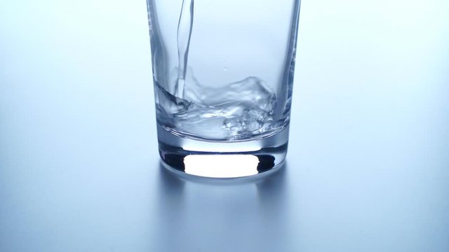 Pouring Water Into Tall Glass. slow motion