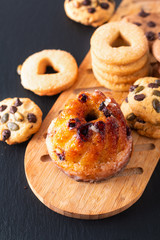 Food Breakfast or snack concept european Gugelhupf, Kougelhopf, kouglof yeast Bundt ring cake with cookies on black background
