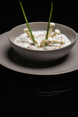 Enoki cream soup. Exquisite dish. Creative restaurant meal concept. Haute couture food on black. Fine dining concept.