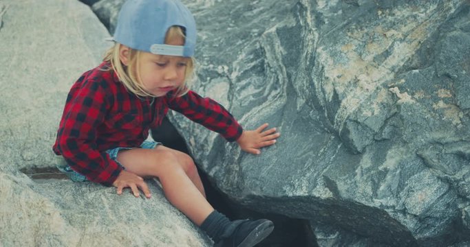 Little toddler climbing on rocks
