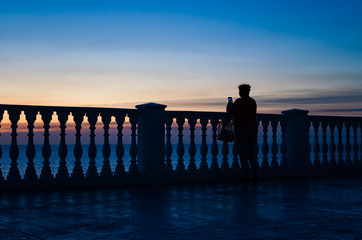 Fence of balusters against the sunset and the sea