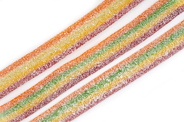 Multicolor gummy candy sweets on white background. Colored marmalade in the sugar on the yellow background. Natural rainbow colored marmalade candy. Liquorice candy