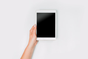 Modern workspace with woman hands and tablet pc copy space on white color background. Top view. Flat lay style. Minimalism