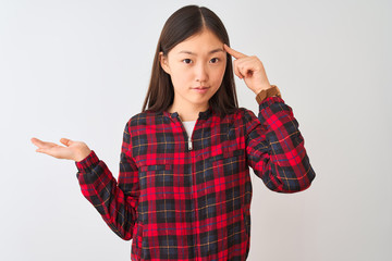 Young chinese woman wearing casual jacket standing over isolated white background confused and...