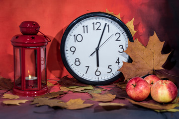 Red lantern lamp with candle and apples on red background.