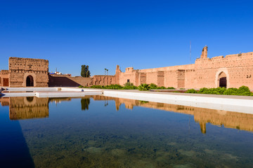 Sightseeing of Morocco. El Badi Palace in Marrakech medina with reflection in water pond. A popular architectural and tourist attraction.