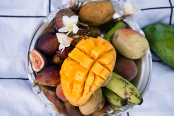 A plate of assorted fruits, sliced mango.