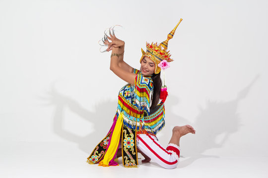 The beautiful woman wearing Thai southern folk dancing costume,made from colorful bead,put headdress on her head,kneel down and raise hands up in the air,show basic pattern of dancing