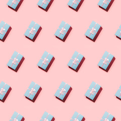 Open composition of many blue pastel gift boxes on pink in diagonal.