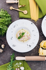 Spaghetti with olive color embellished with greenery, rolling pin, pasta.