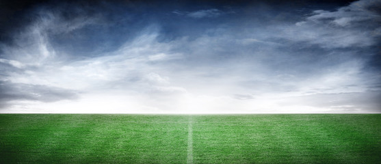 Empty Soccer Playing Field with Atmospheric Cloud Sky Horizon Background