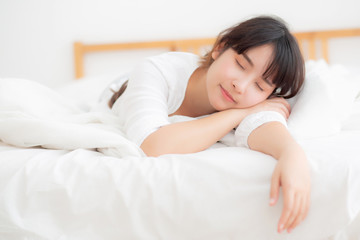 Obraz na płótnie Canvas Beautiful asian young woman tired sleeping lying in bed comfortable and happy, girl with relax and leisure in the bedroom, health and wellness concept.