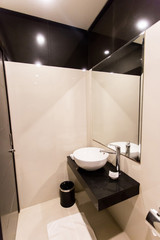Black and white sink with mirror in a luxury granite bathroom interior. Apartment or hotel bathroom