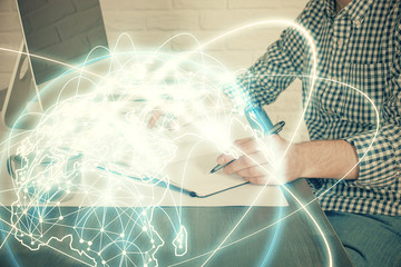 Fototapeta premium Multi exposure of businessman working on laptop on background. International business hologram in front. Concept of success.