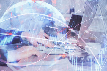 Multi exposure of chart with man typing on computer in office on background. Concept of hard work.