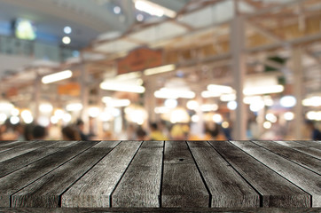 empty wooden top table or wooden terrace with abstract blurred light bokeh in department store shopping mall, copy space for display product or object presentation, marketing and advertisement concept