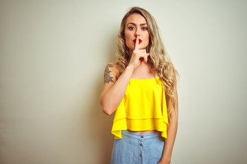Young beautiful woman wearing yellow t-shirt standing over white isolated background asking to be...