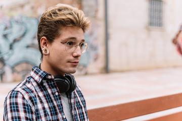 Hipster guy in glasses and piercings looking away