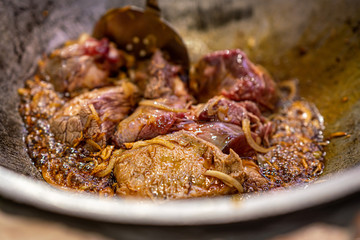 Cooking traditional Uzbek pilaf from rice, meat, carrots