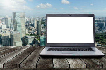 laptop notebook computer with white blank screen on desk with during sunrise and cityscape background, advertisement, workspace, internet technology, online social media and searching data concept
